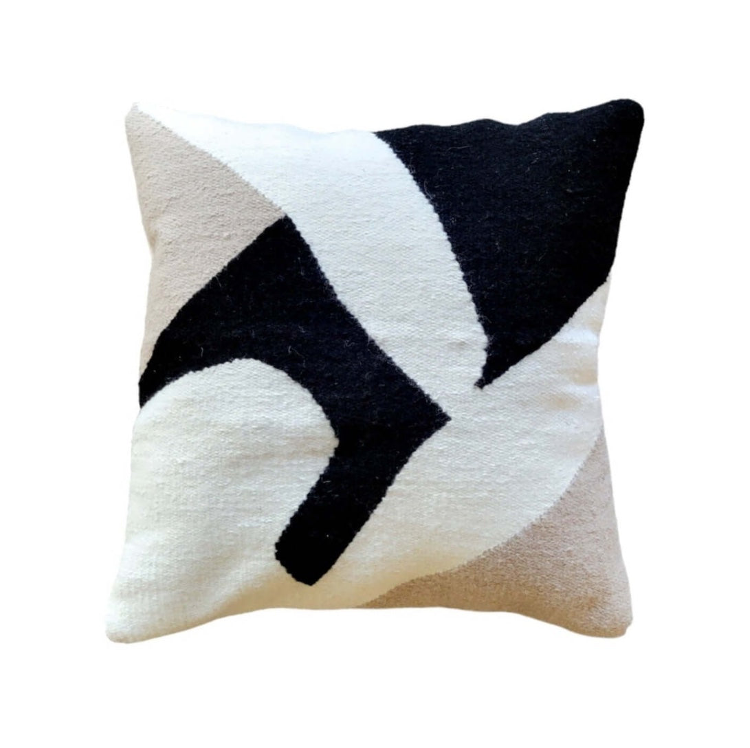 Decorative pillow with black and white geometric pattern on a beige background