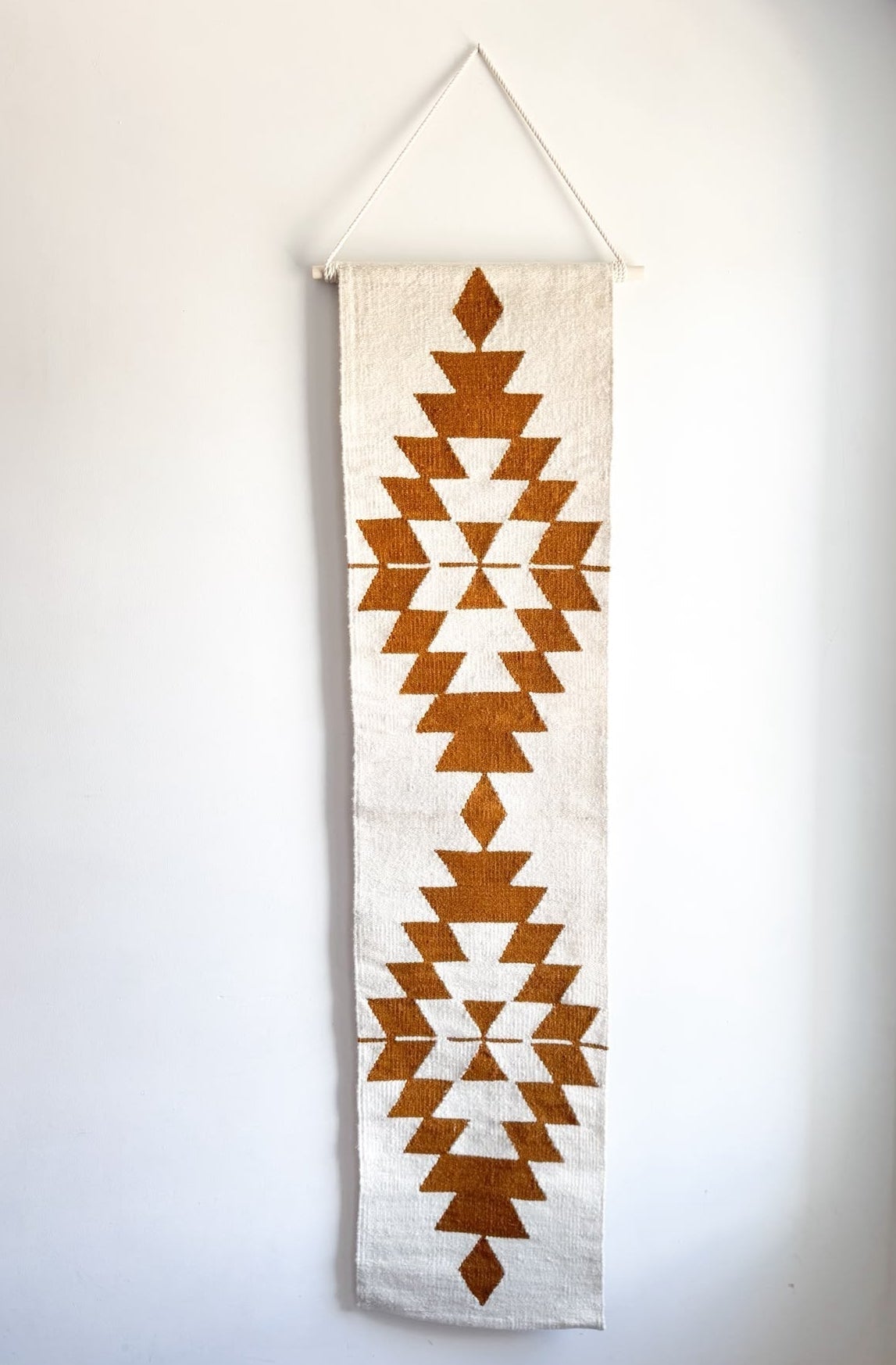 Decorative wall hanging with geometric pattern on a plain background