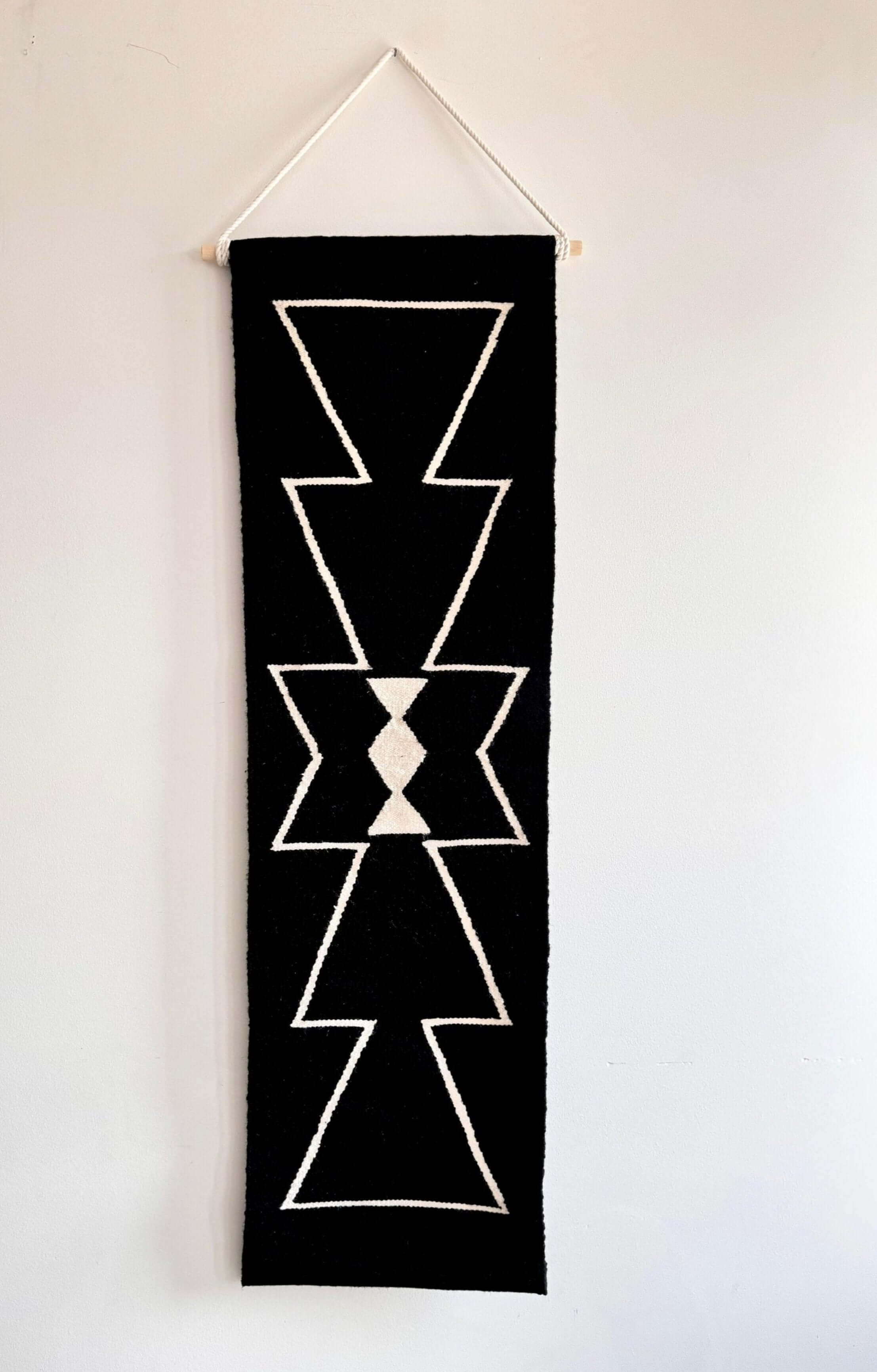 Black handwoven wall hanging rug tapestry with geometric white patterns