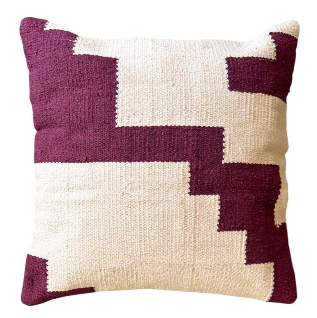 Decorative pillow with geometric pattern in purple and pink