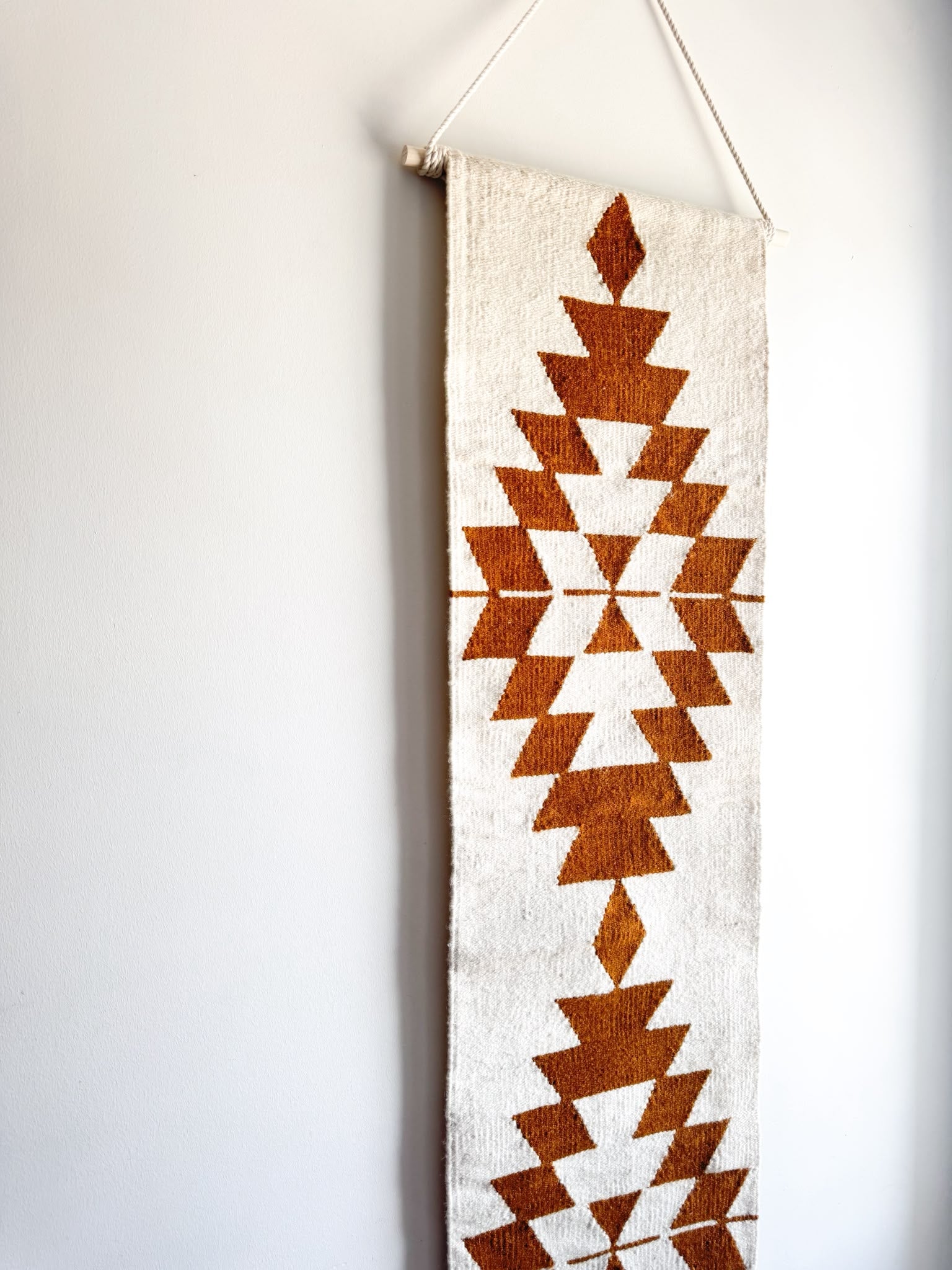 Decorative wall hanging with geometric pattern on a plain background