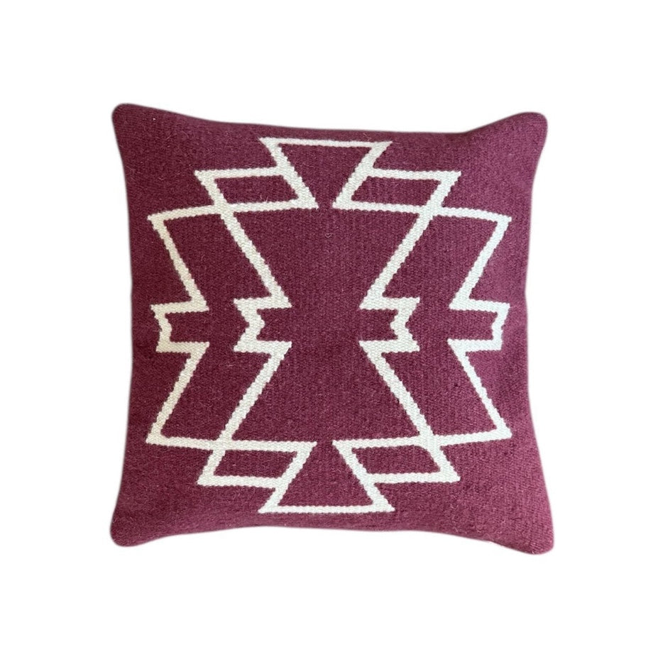 Maroon pillow with white geometric pattern on a Maroon background