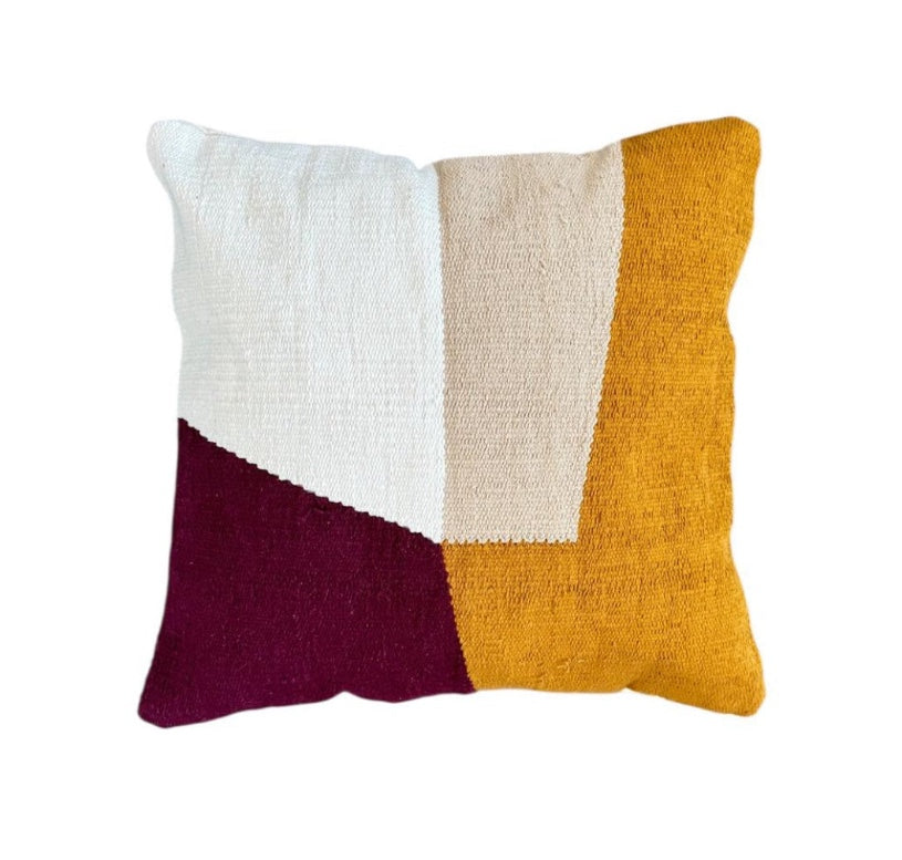 Color-blocked pillow with white, beige, orange, and maroon sections on a white background
