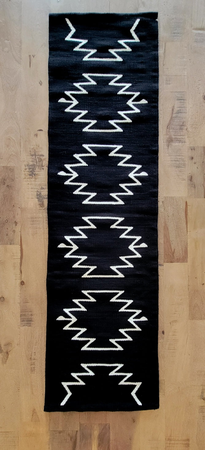 A black and white geometric patterned cotton table runner