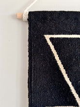 Close-up of a black handwoven wall hanging