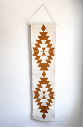 Decorative wall hanging with geometric pattern on a plain background