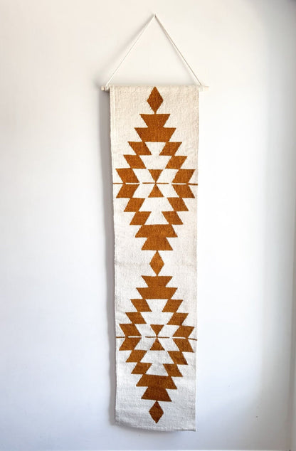 Decorative wall hanging with geometric pattern on a plain background