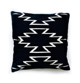 Black pillow with white zigzag pattern on a white background