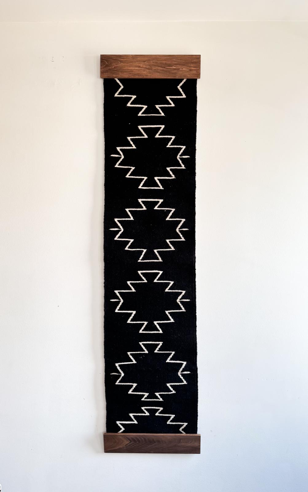 Vertical black banner with white geometric pattern and wooden frame on a light background