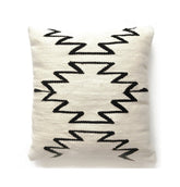 Decorative pillow with black zigzag pattern on a white background