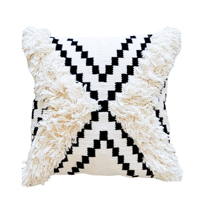 Decorative pillow with black and white zigzag pattern and fringed edges on a white background