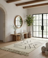 Modern interior with a geometric rug, wooden bench, and decorative plants.