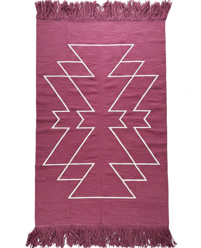 Deep wine rug with white geometric pattern and fringes on a white background