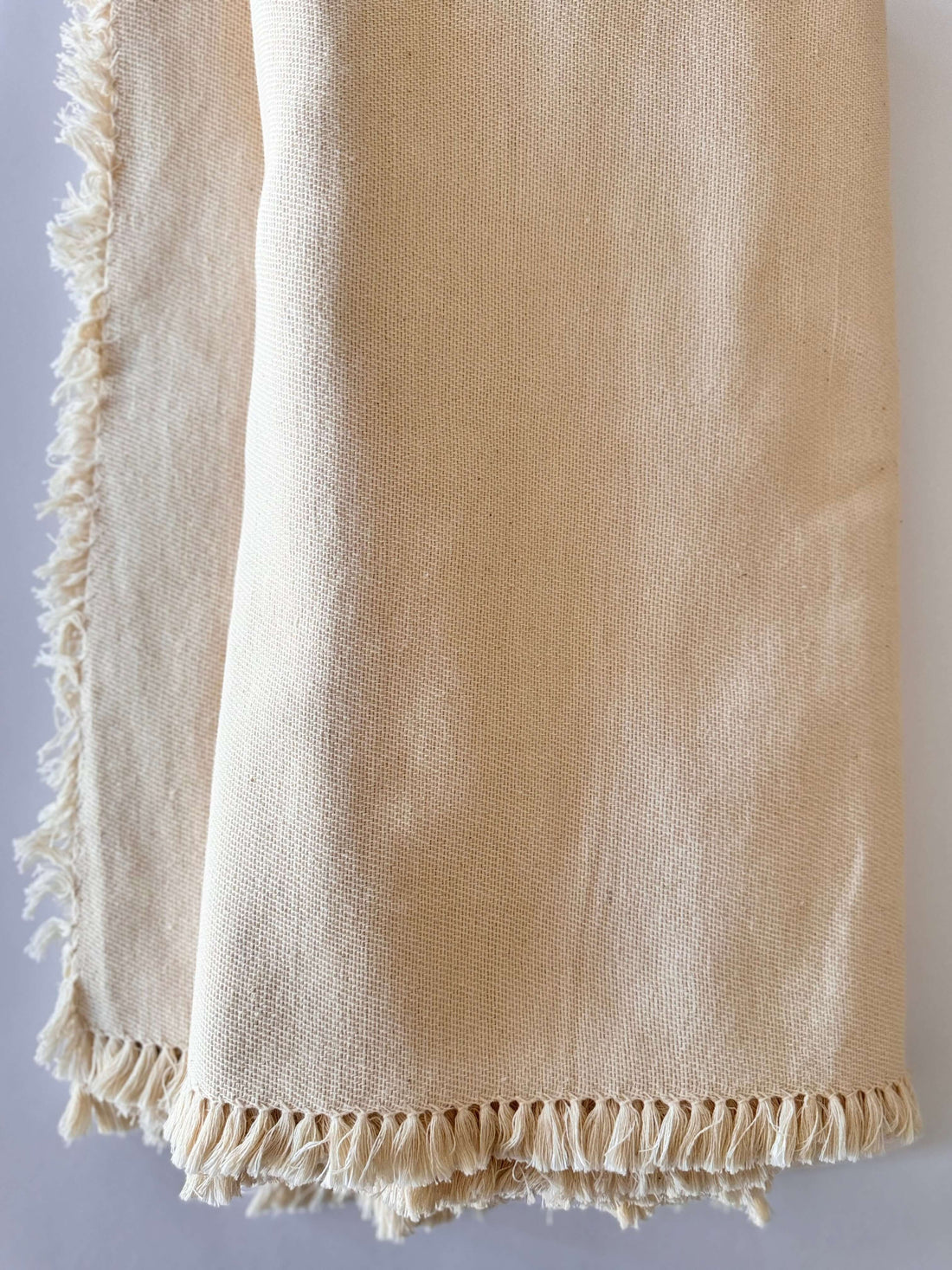 Beige blanket with frayed edges