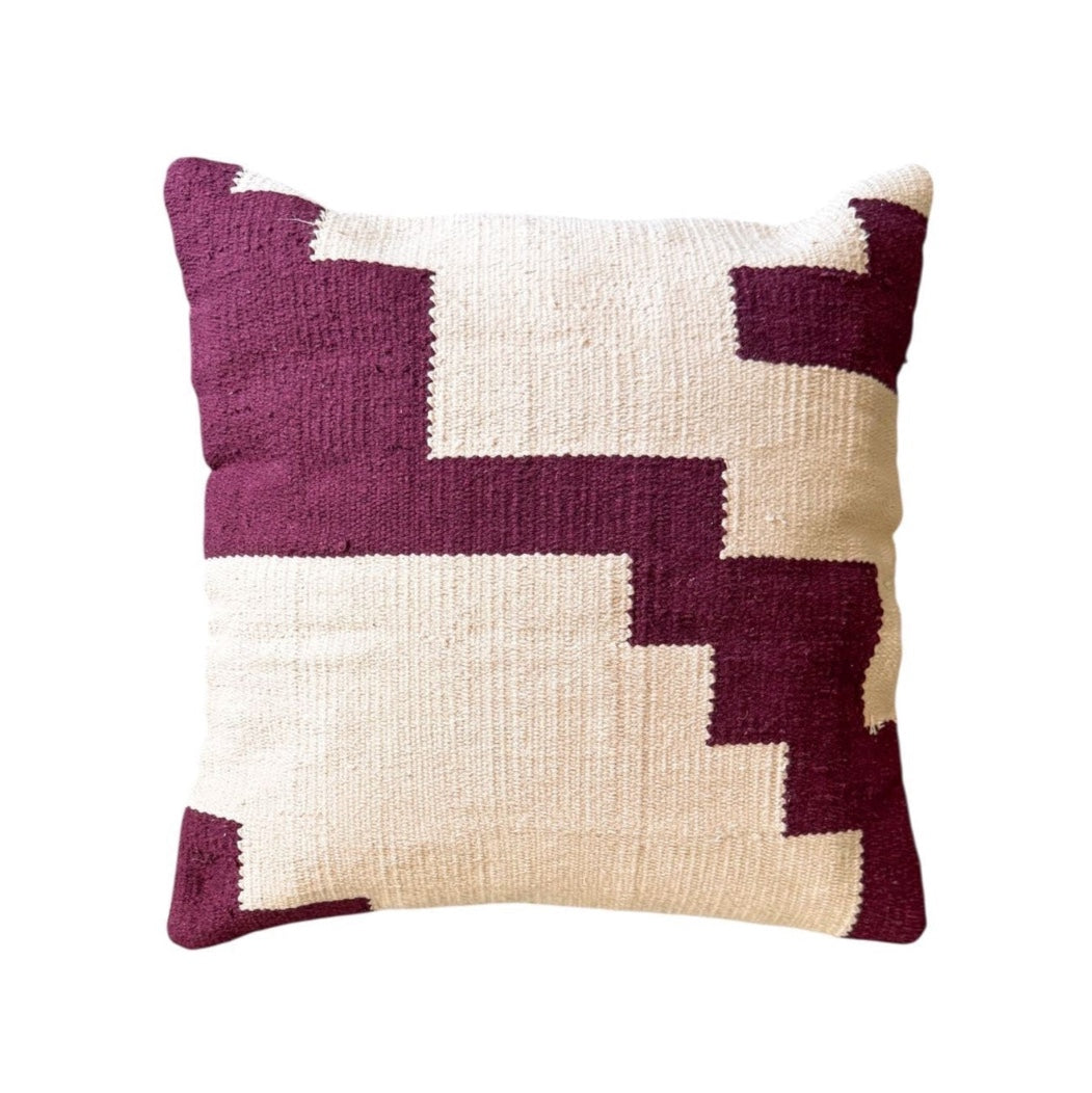 Decorative pillow with geometric pattern in purple and beige on a white background