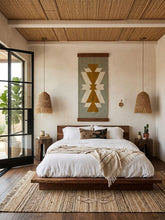 Cozy bedroom with wooden platform bed, geometric wall art, and natural lighting.