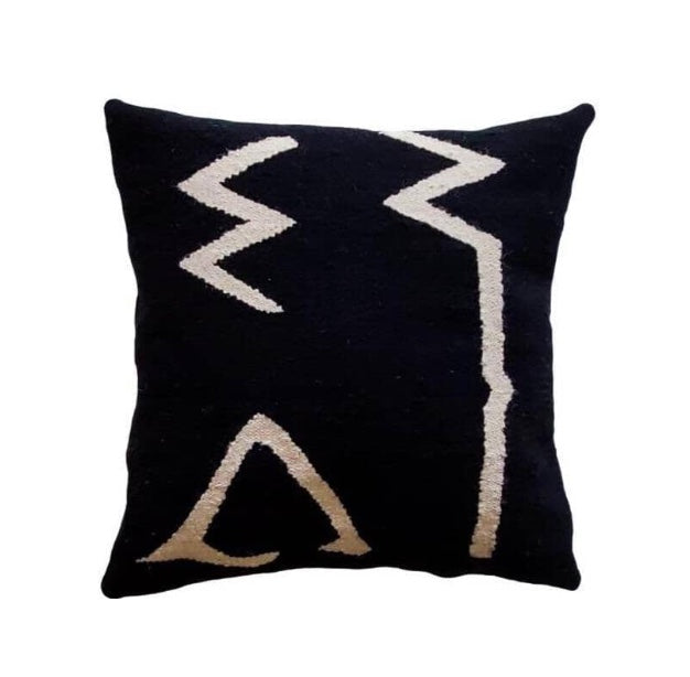 Black pillow with white and beige geometric patterns
